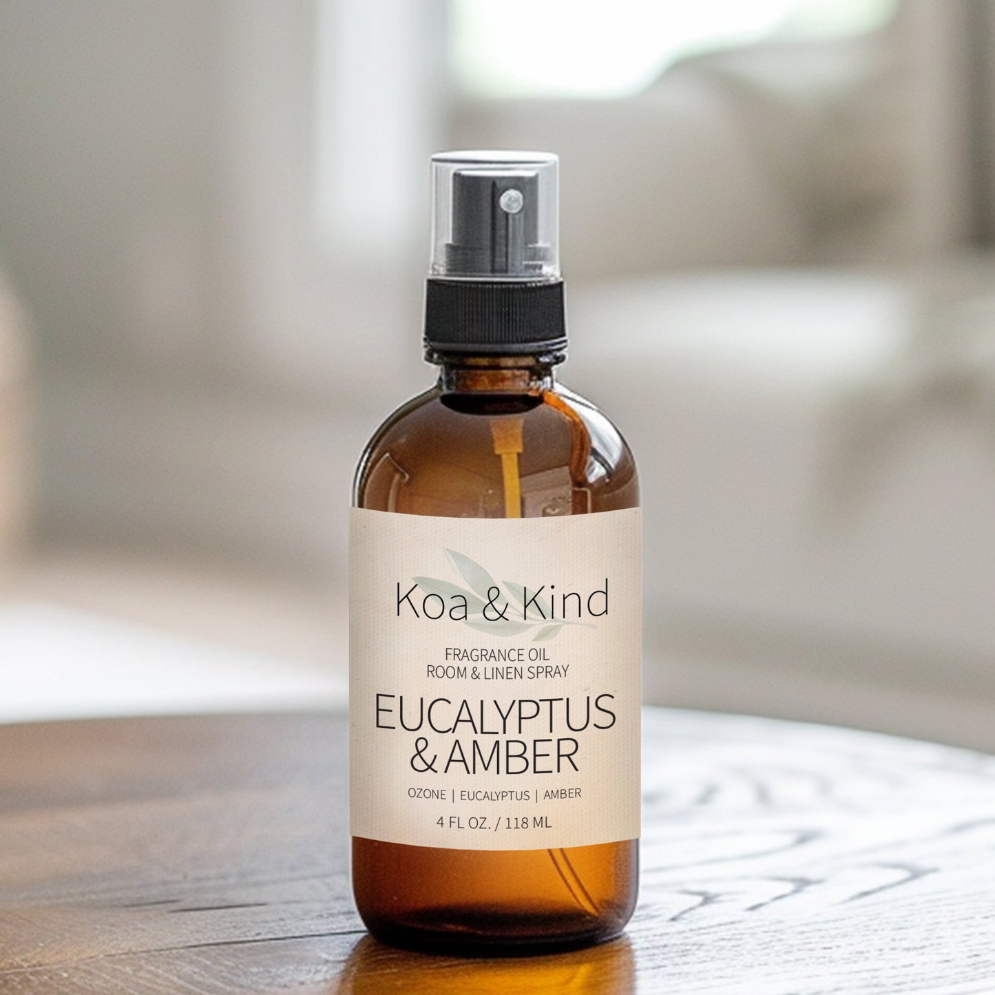 Koa & Kind fragrance oil bottle on a wooden surface with a blurred background
