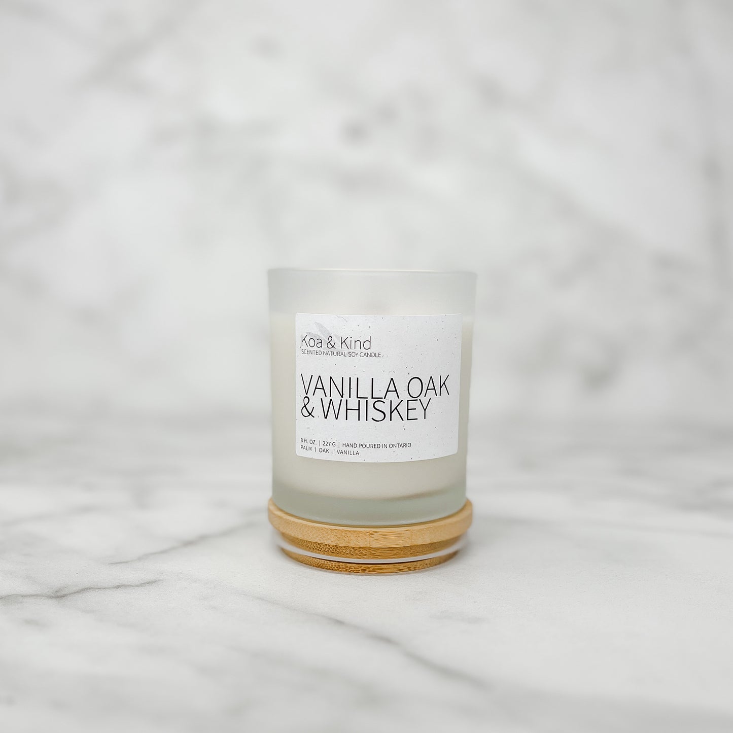 Candle with a label on a white marble surface