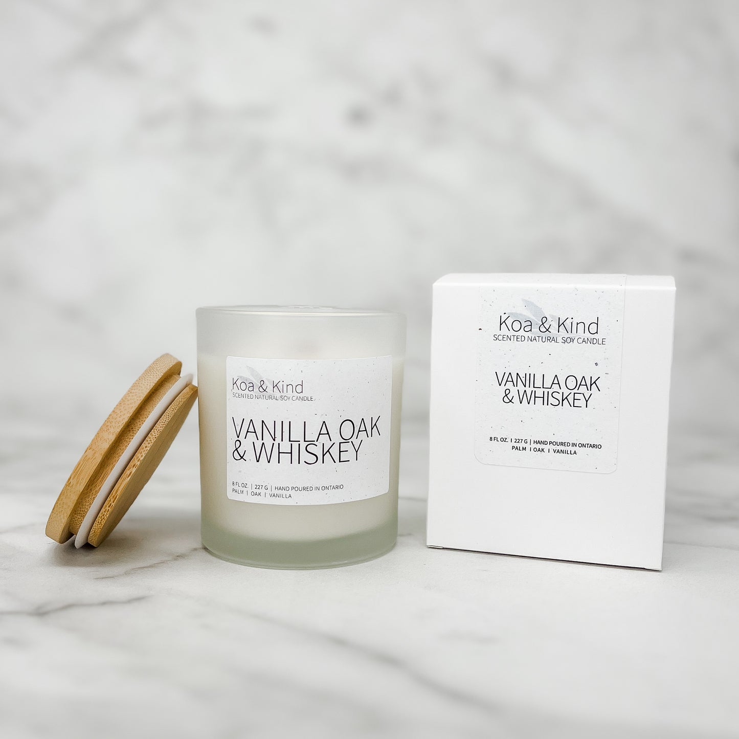 Koa & Kind Vanilla Oak & Whiskey candle with packaging on a marble surface