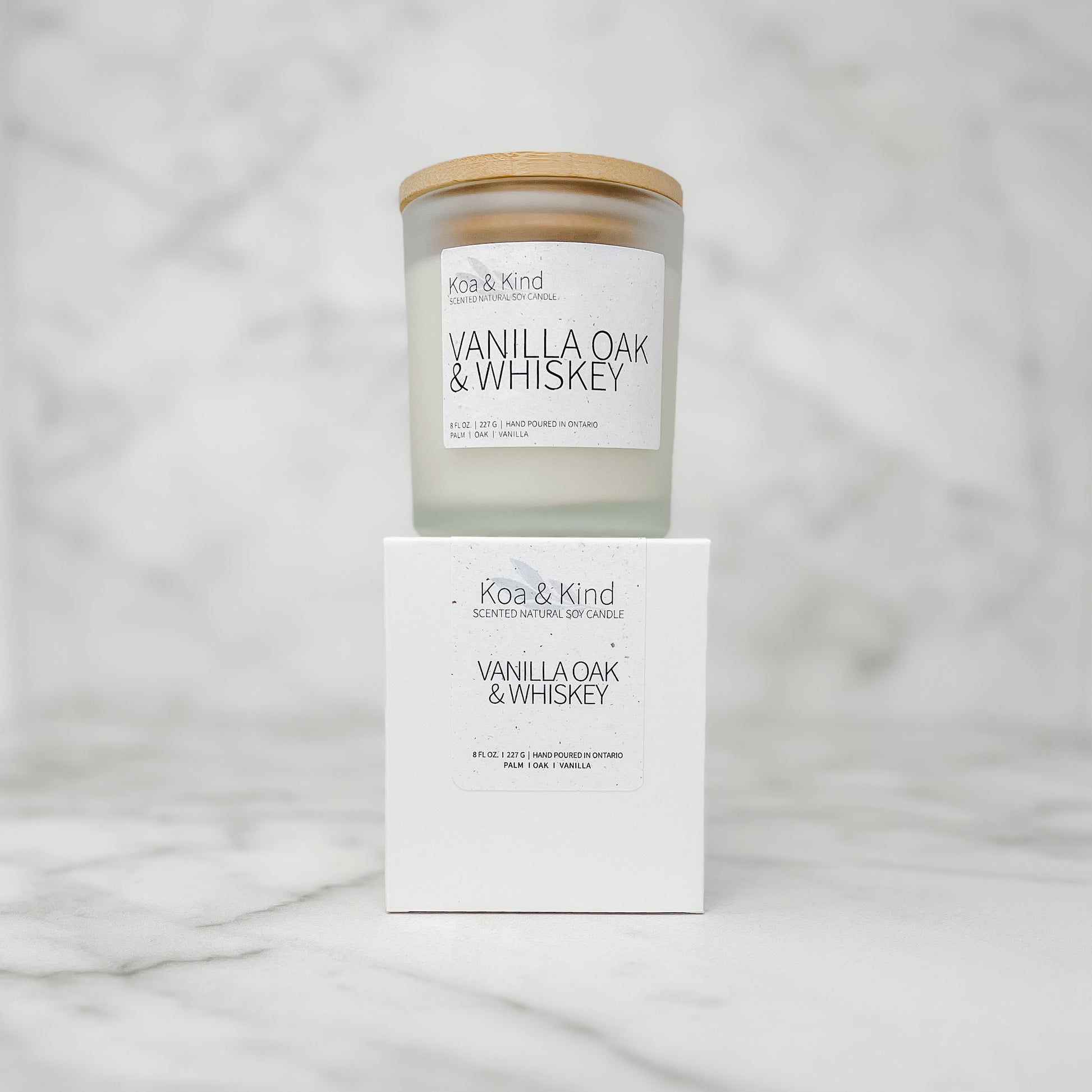 Koa & Kind Vanilla Oak & Whiskey candle and its packaging on a marble surface